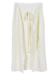 Detail showing the cream white seersucker textured fabric and tie-up design of the skirt