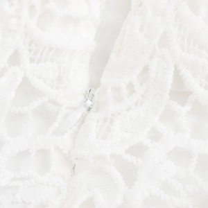 Détail de la robe élégante en dentelle blanche avec fermeture éclair invisible au dos