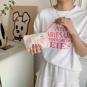 Close-up of pink floral lace makeup bag with woven wristlet and brand tag
