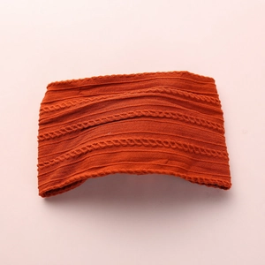 Detail shot of orange nylon baby headband with soft cable knit jacquard texture