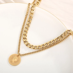 Detail of layered gold coin necklace with Elizabeth II engraving and thick chain