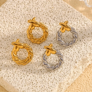 Détails macro de boucles d'oreilles torsadées en forme de X plaquées or 18 carats et argent