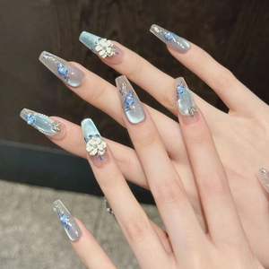 Detailed view of long trapezoidal press-on nails with 3D white petals and blue floral art