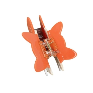 Gros plan sur la pince à cheveux papillon orange et crème avec ressort en métal doré
