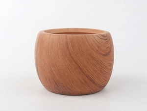 Detail of round ceramic planter with realistic wood grain texture and bamboo tray