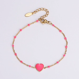 Detailed macro of gold-plated stainless steel chain with pink enamel heart and beads