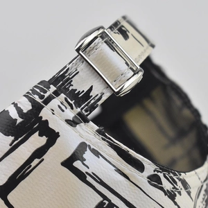 Detail of adjustable metal buckle and black and white tie-dye print on the canvas baseball cap