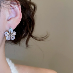 Close-up of a model wearing the silver zircon flower earrings with sparkling petals