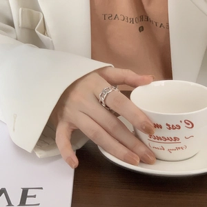 Detail of S925 sterling silver chain ring on model hand holding a coffee cup
