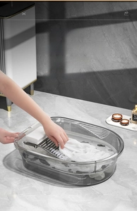 Détail de la bassine grise translucide avec planche à laver intégrée et surface rainurée