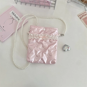 Dettaglio della borsa a tracolla rosa con fiocchi ricamati e catena di perle bianche