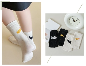 Detail of speckled cotton crew socks with animal embroidery in white and black