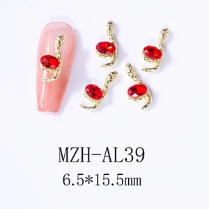 Macro shot of 3D gold snake nail charms with red gemstone inlay, size 6.5x15.5mm