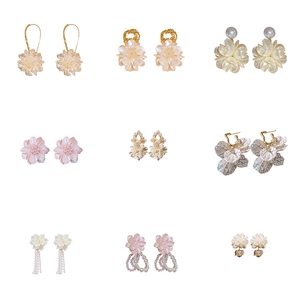 Lot de neuf boucles d'oreilles fleurs en acrylique blanc et doré pour femmes élégantes
