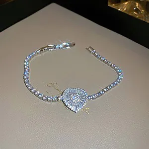 Detailed view of a silver heart tennis bracelet with sparkling zirconia on leather texture