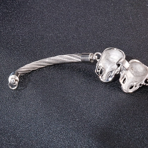 Gros plan détaillé du bracelet en câble d'argent tressé avec boucle en métal ornée