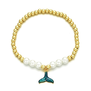Golden beads and pearls bracelet featuring a dark blue whale tail pendant on white background