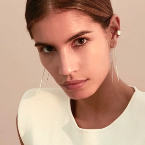 Detail of elegant gold S925 sterling silver tassel earrings and matching ear cuff on model
