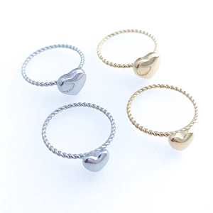 Flat lay of heart-shaped stainless steel twist rings in gold and silver colors