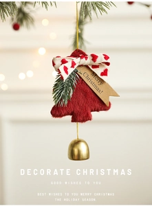 Close-up of a plush red Christmas tree hanging ornament with a gold metal bell and bow