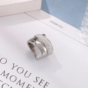 Macro view of wide stainless steel ring featuring multi-layer crisscross bands and white zircons