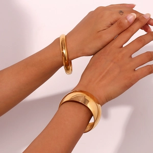Detail of 18K gold plated stainless steel chunky and slim bracelets set on wrist