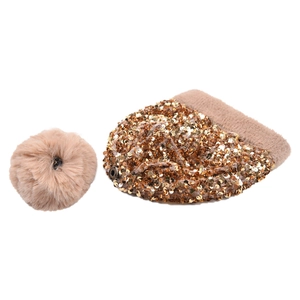 Detail view of gold sequin knit beanie with detachable faux fur pom-pom and snap button