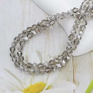 Faceted 6mm grey crystal glass beads for jewelry making on a floral display