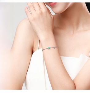 Détail du bracelet en argent S925 avec pierre verte taille émeraude sur le poignet