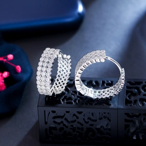 Silver hoop earrings with pave-set cubic zirconia displayed on a black jewelry stand