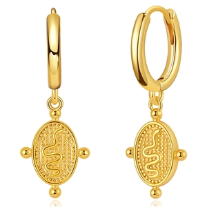 Close-up of gold snake pendant earrings with a textured bohemian finish and polished hoops