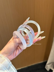 Détail des bracelets en pierre œil-de-chat translucides en lavande, bleu et blanc