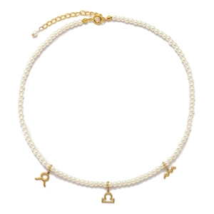 Detailed view of pearl necklace featuring gold zodiac charms and adjustable lobster clasp