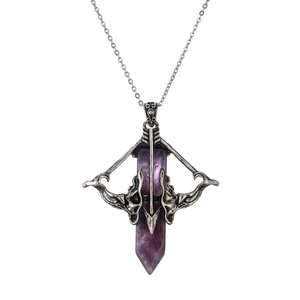 Macro detail of gothic Cupid's arrow pendant with a purple hexagonal crystal stone
