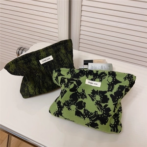 Detail of green and black jacquard fabric cosmetic bags with simple wish woven label