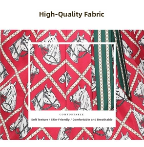 Détail du tissu rouge de la robe avec imprimés tête de cheval blancs et motifs géométriques