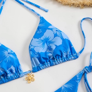 Floral print halter bikini top in royal blue with gold flower charm and tropical pattern