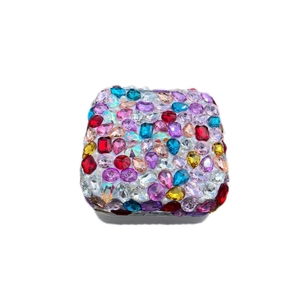 Close-up of portable jewelry box featuring vibrant multicolored rhinestones and pearls