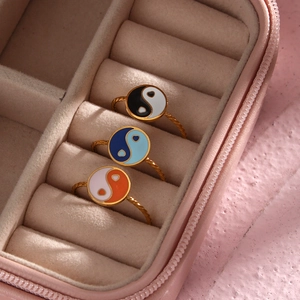 Detailed view of 18K gold-plated yin yang rings with colorful enamel in a velvet box