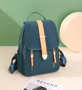 Detailed teal Oxford backpack featuring contrast orange straps and sleek buckle detail