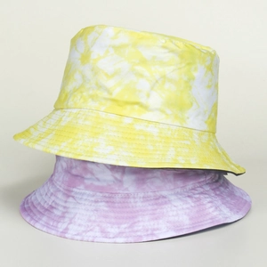 Détail de chapeaux bobs tie-dye en jaune et violet avec texture de toile de coton