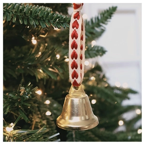 Detail of a golden star cut-out bell with red heart embroidered ribbon for Christmas tree