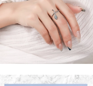 Close-up of a silver snake open ring with sparkling cubic zirconia on a female finger