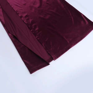 Détail d'une robe de soirée en velours bordeaux avec fente latérale haute et finitions