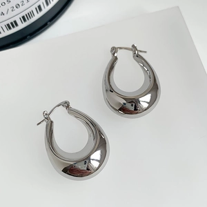 Detailed view of high-polished silver drop earrings with a sleek mirror finish surface