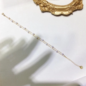 Detail of 18k gold double-layer bracelet with natural pearls and Au750 hallmark