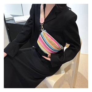 Close-up of rainbow woven belt bag with wide colorful strap on a black blazer