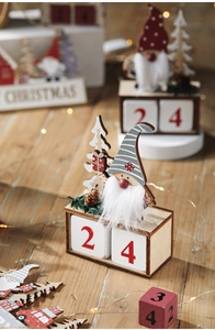 Close-up of wooden Christmas countdown calendar with plush gnome and date cubes
