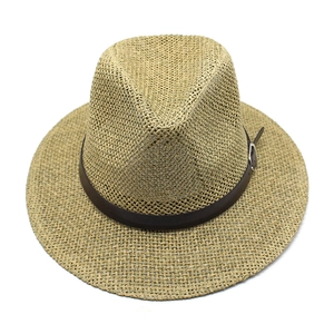 Detailed close-up of handmade straw jazz hat with brown leather band and silver buckle