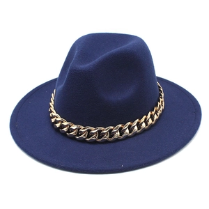 Detail of navy blue wool felt fedora featuring a thick decorative gold metal chain